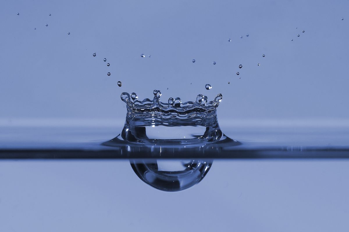 Einschlag eines Tropfens auf die Wasseroberfläche. Aufgenommen mit einer selbstgebauten Lichtschranke, einer Sony Alpha 500, einem Sony HVL-F42AM Blitzgerät und einem Minolta AF 100mm f2.8 macro Objektiv.